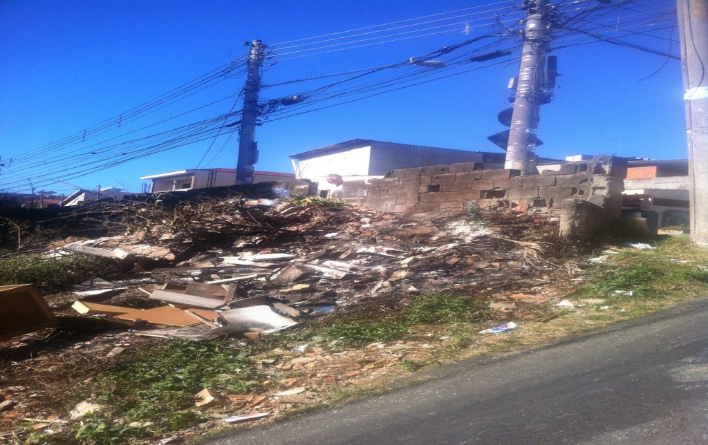 Lixo e entulho de terreno ocupam calçada da rua Álvaro Silva, no bairro do Limão.
