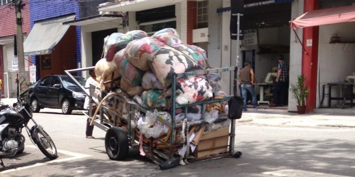 Catadores coletam irregularmente sacos de retalhos que são descartados por lojas, nas ruas do Bom Retiro.